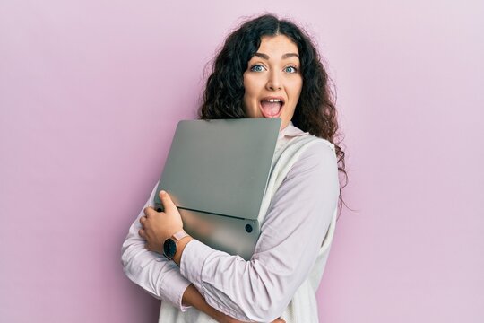 Young Brunette Woman With Curly Hair Hugging Laptop With Love Celebrating Crazy And Amazed For Success With Open Eyes Screaming Excited.