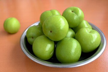 green plums in a plate