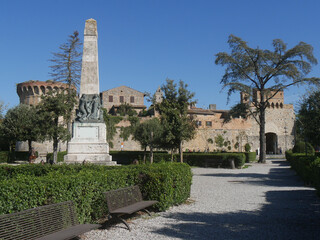 Fototapeta na wymiar Gardens with obelisk in front of the walls of San Gimignano with the San Giovanni gate and the San Francesco bastion