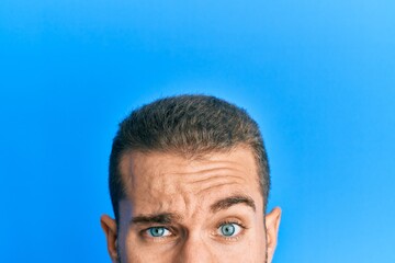 Young caucasian man showing head and half face skeptic and nervous, frowning upset because of problem. negative person.
