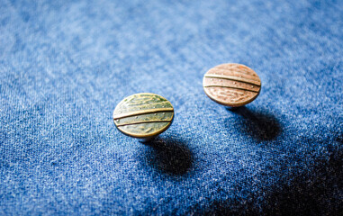 macro close up of buttons on denim textile indigo blue cotton