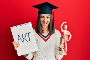 Young brunette girl graduated on art winking looking at the camera with sexy expression, cheerful...