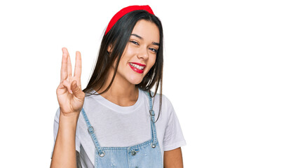 Young hispanic girl wearing casual clothes showing and pointing up with fingers number three while smiling confident and happy.