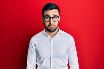 Young hispanic businessman wearing shirt and glasses depressed and worry for distress, crying angry...