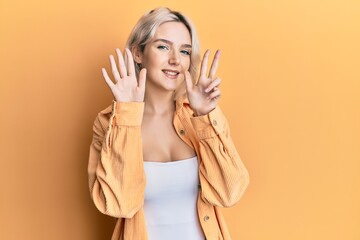 Young blonde girl wearing casual clothes showing and pointing up with fingers number eight while smiling confident and happy.