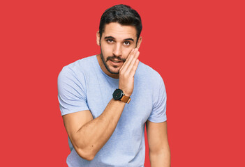 Young hispanic man wearing casual clothes hand on mouth telling secret rumor, whispering malicious...