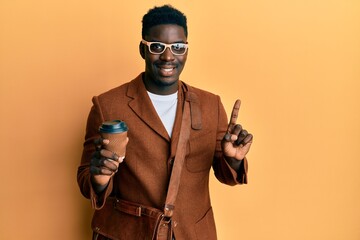 Handsome black man wearing business bag and drinking coffee smiling with an idea or question pointing finger with happy face, number one