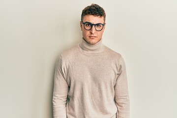 Hispanic young man wearing casual turtleneck sweater skeptic and nervous, frowning upset because of problem. negative person.