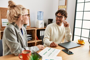 Two hispanic business workers smiling happy working at the office.