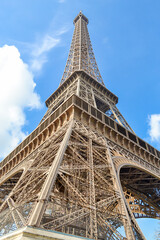 Side view of the Eiffel tower seen from beneath in Paris, blue skys and almost no clouds