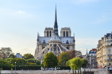 Rear view from Notre Dame Cathedral with spire in Paris, across Sena river, with blue and warn sky and almost no clouds