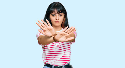 Young hispanic girl wearing casual clothes rejection expression crossing arms doing negative sign, angry face