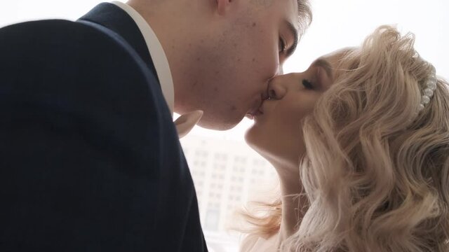 Newlyweds kiss at the big window