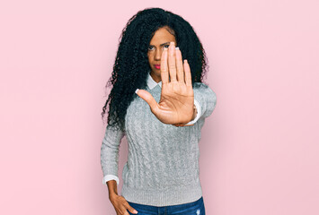 Middle age african american woman wearing casual clothes doing stop sing with palm of the hand....