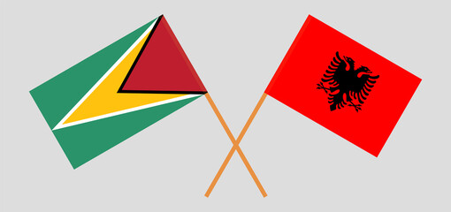 Crossed flags of Guyana and Albania. Official colors. Correct proportion