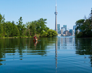 Canoeistss leave the Toronto Islands heading back toward downtown Toronto and the CN Tower.