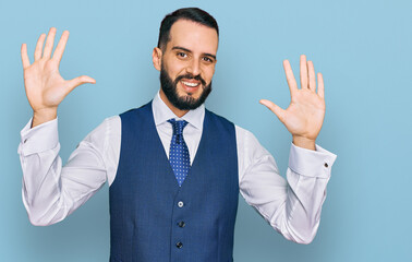 Young man with beard wearing business vest showing and pointing up with fingers number ten while smiling confident and happy.