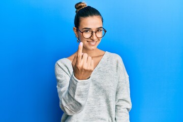 Young hispanic woman wearing casual clothes beckoning come here gesture with hand inviting welcoming happy and smiling