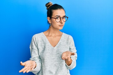 Young hispanic woman wearing casual clothes clueless and confused with open arms, no idea concept.