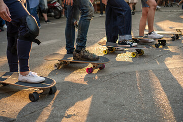Activity leisure skateboard lifestyle concept. Legs group of athletic people playing surf skate on the road with sunlight in the evening for workout. © kaew6566