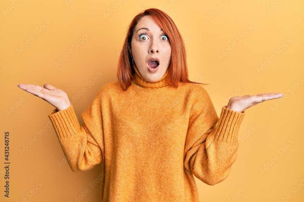 Poster beautiful redhead woman presenting with open palm afraid and shocked with surprise and amazed expres