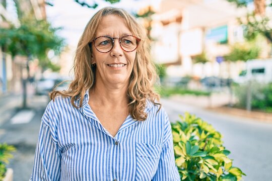 Middle age caucasian woman smiling happy standing at the city.