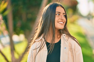 Young hispanic girl smiling happy standing at the park.