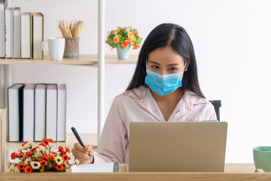 Freelance Young Woman Wears Masks Protect Against Airborne Disease And During Outbreak Of Covid 19 While Working With Laptop From Home. Society Distance Prevent The Spread Of Corona Virus Concept.