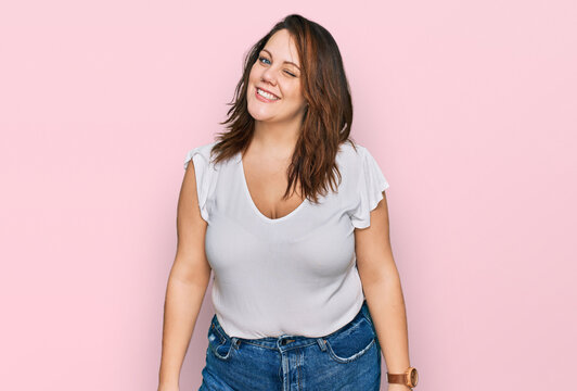 Young plus size woman wearing casual white t shirt winking looking at the camera with sexy expression, cheerful and happy face.