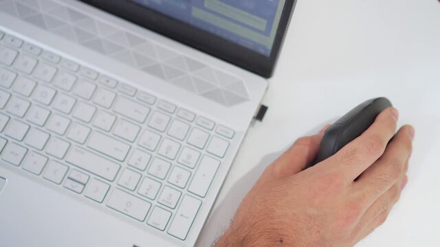man's hand using an ergonomic vertical mouse while typing on his computer. 4k video