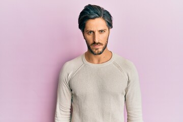 Obraz premium Young hispanic man wearing casual winter sweater skeptic and nervous, frowning upset because of problem. negative person.