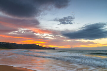 Fototapeta na wymiar Sunrise at the seaside with pastel coloured clouds