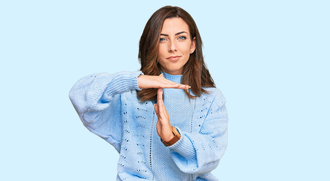 Young Brunette Woman Wearing Casual Winter Sweater Doing Time Out Gesture With Hands, Frustrated And Serious Face