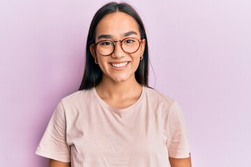 Young asian woman wearing casual clothes and glasses with a happy and cool smile on face. lucky person.