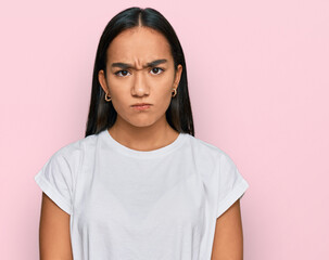 Young asian woman wearing casual white t shirt skeptic and nervous, frowning upset because of problem. negative person.