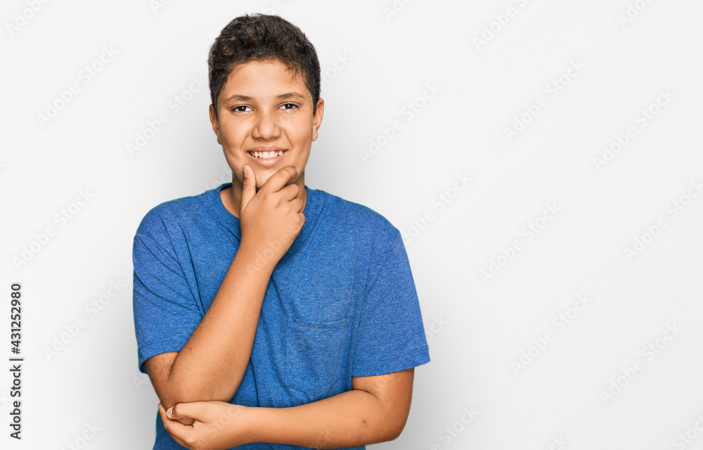 Wall mural Teenager hispanic boy wearing casual clothes looking confident at the camera smiling with crossed arms and hand raised on chin. thinking positive.