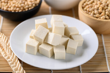 Sliced tofu on white dish and soybean seeds, Healthy vegan food