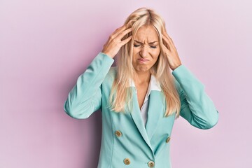 Young blonde woman wearing business clothes suffering from headache desperate and stressed because pain and migraine. hands on head.