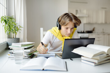 Teenager boy study at home. Online education and distance learning for children. School boy doing...