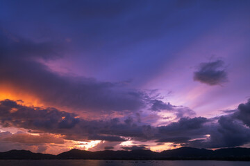 Fototapeta na wymiar Dramatic clouds in sunset or sunrise over the mountains and the sea of Phuket islands in Thailand