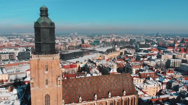 Aerial view of St. Mary Magdalene and Elisabeth Churches in the city of Wroclaw, Poland. View of buildings in the city from the top. Scenic blue sky in the background. Daytime Footage. 