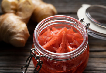 Red pickled ginger placed on an old wooden background.