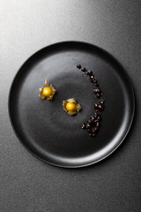 gooseberry on a black dish with a splash of elderberry jam