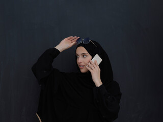 Young muslim businesswoman in traditional clothes or abaya talking on the smartphone