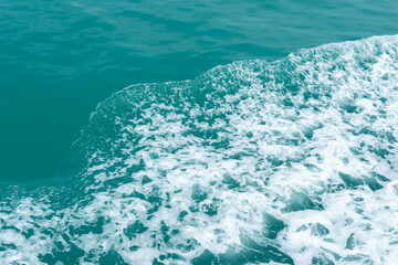 Trail on the water from the boat, sea waves bubble foam from boat. Stock photo image of ocean waves and sea foam caused by the sail of a speed boat, water surface behind of fast moving motor boat