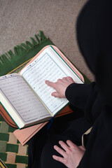 Middle eastern woman praying and reading the holy Quran