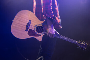 A man holding an acoustic guitar in his hands.