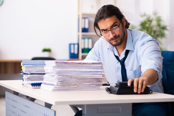 Young male employee unhappy with excessive work in the office