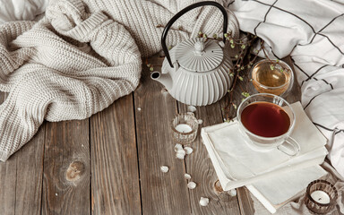 Cozy home composition with a cup of tea, books and decorative details.