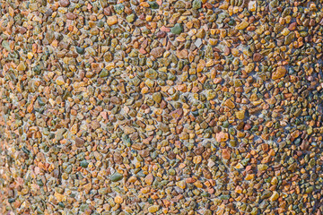 small multi-colored stones on the shore of the lake